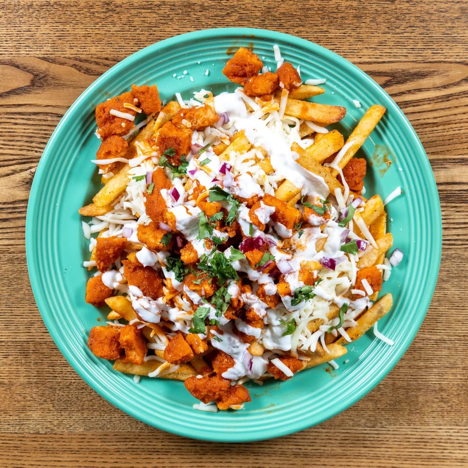 Fairweather's loaded fries with crispy chicken, cheese, red onion, cilantro, and white sauce.